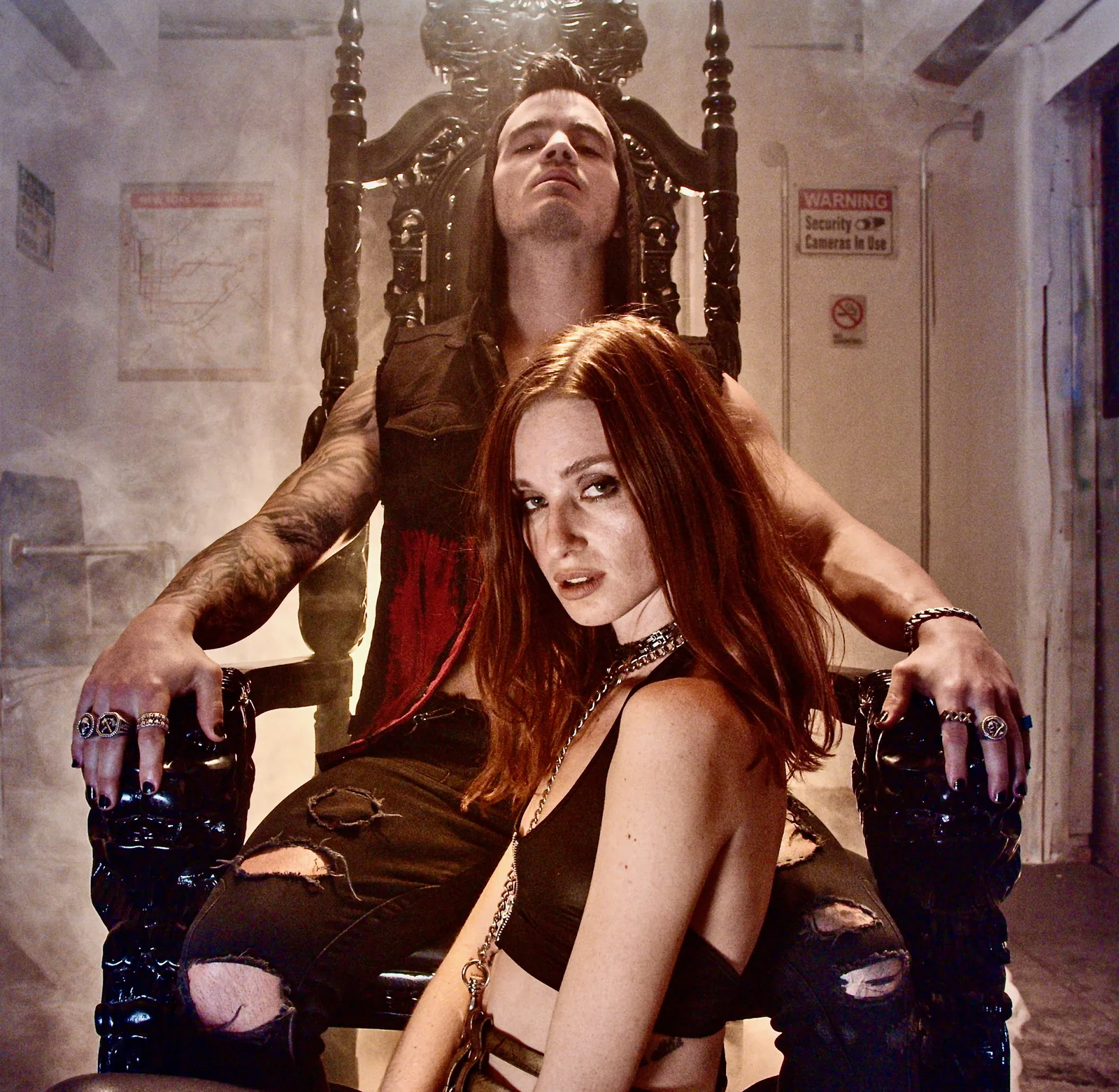 Daemon Grey on the black throne from the King of Sin era, head tilted back, a red-haired woman leaning across his lap in the smoke.